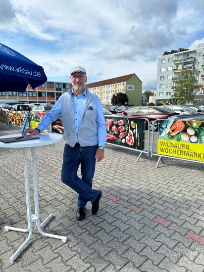 Bürgermeister Nerlich steht lässig an einem Stehtisch und ist bereit für das nächste Gespräch